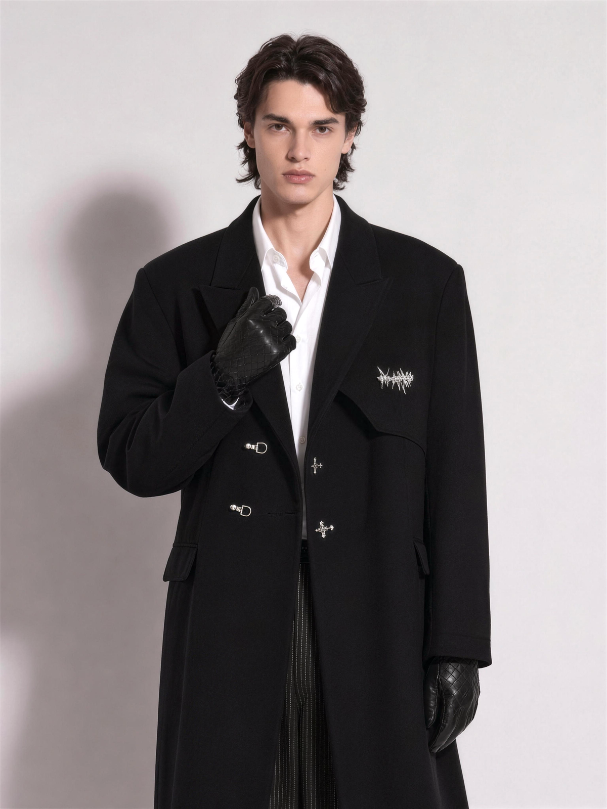 Chest-up view of the overcoat showing the notch lapel, welt pocket and chest graphic
