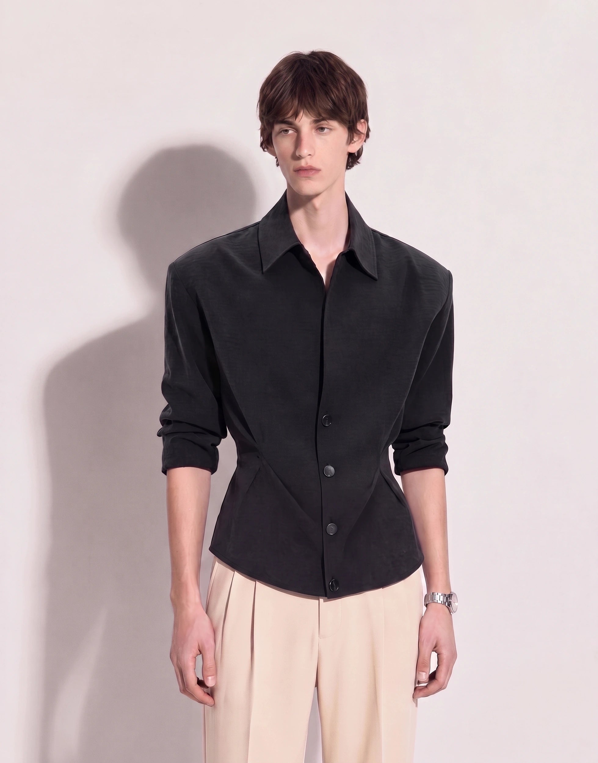 Structured button-up shirt with cinch side detail in dark charcoal, half body front view showing padded shoulders and cinched waist