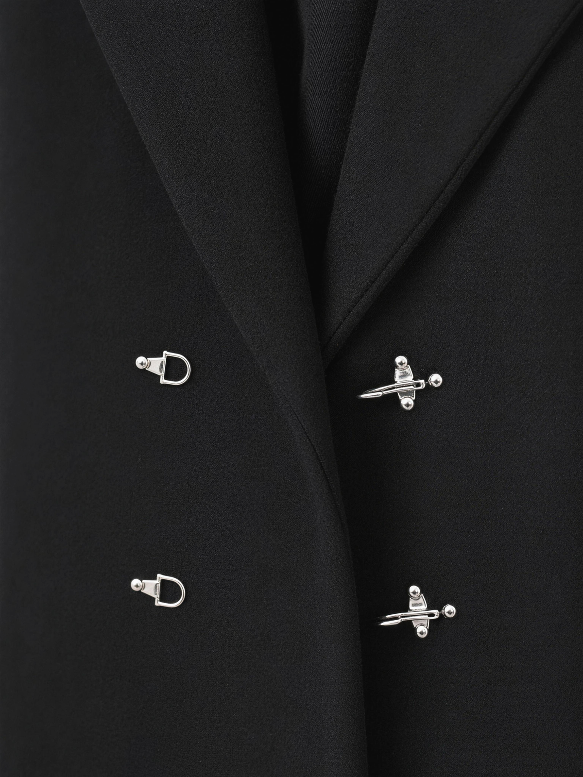 Close-up of the polished silver fireman clasp hardware and wire D-rings on the coat front