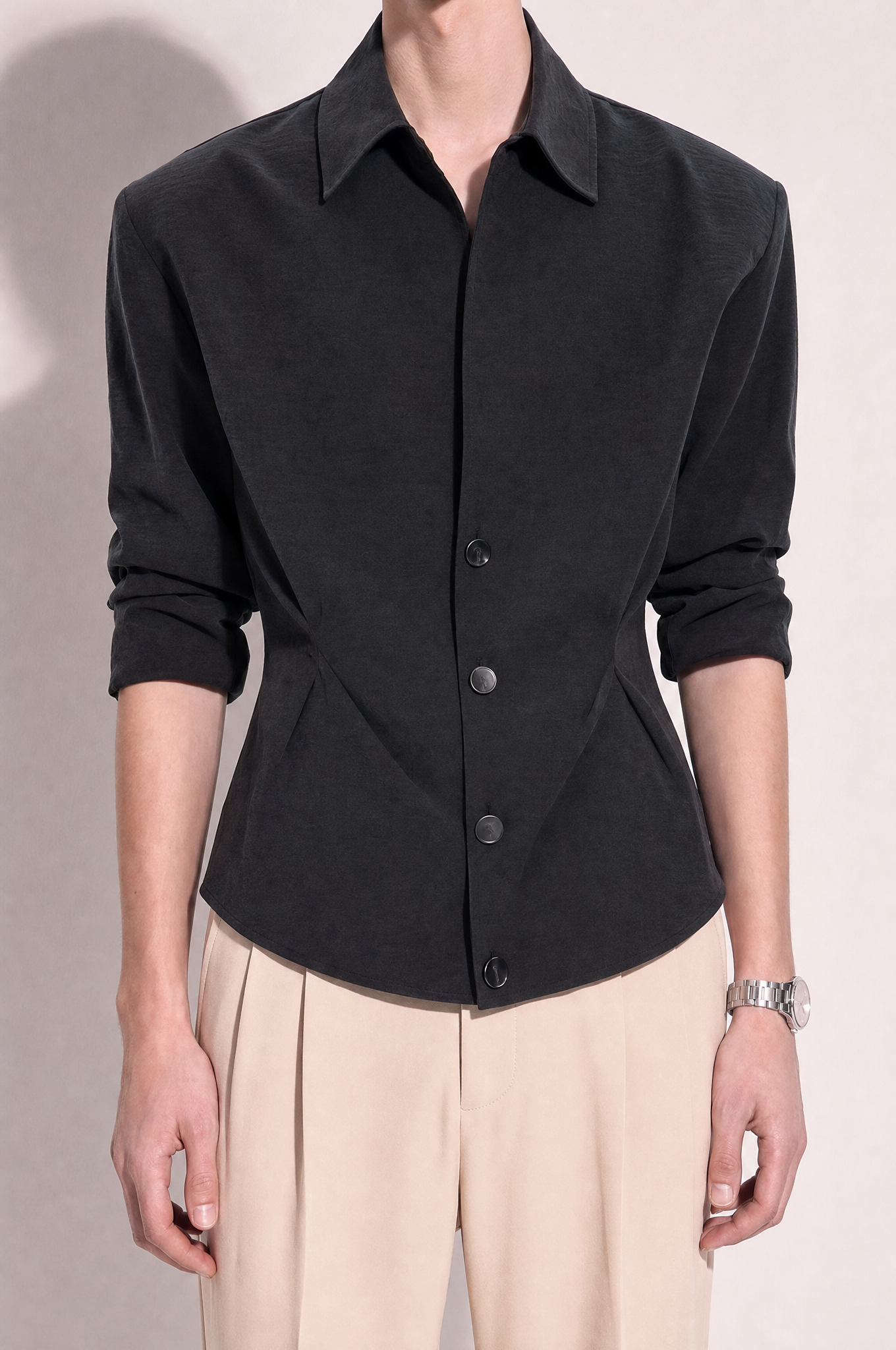 Structured button-up shirt with cinch side detail in dark charcoal, close torso crop showing concealed placket, four buttons and crinkle texture